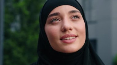 Portre dişlek, mutlu Müslüman kadın Arap kız Hintli, İslami kadın, siyah tesettüre bürünmüş, başını kaldırıp baktığında açık havada hayal kurmayı hayal et.