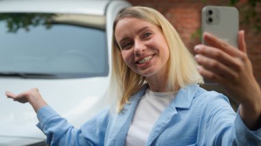 Neşeli Kafkasyalı kadın araba sahibi video konuşması yapan mutlu kız sürücü konuşma blogu konuşan cep telefonu kadın iş kadını şehir taşımacılığında yeni lüks otomobil kiralama hizmeti gösteriyor