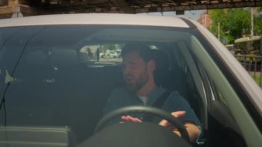 Araba süren beyaz adam şarkı söylüyor. Otomobil radyosu çalıyor. Mutlu, kaygısız iş adamı, lüks araba sahibi.