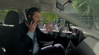Stresli iş adamı, şoför, iş adamı, iş adamı, otomobil içinde iş adamı, cep telefonu, öfkeli, çatışmalı araba sürücüsü, trafik sıkışıklığı, cep telefonu iletişimi, otomobil yolculuğu.