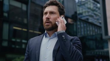 Beyaz adam resmi takım elbiseli iş adamı iş adamı girişimci iş adamı emlakçı şehir merkezindeki cep telefonlu ofis binasının önünde sohbet eden cep telefonu konuşmasına cevap veren emlakçı.