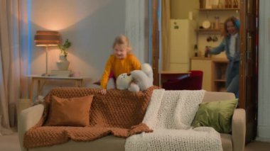 Mutlu bir aile taşınıyor, komik çocuklar, çocuklar, kardeşler, babalar kanepeye oturuyor, tatilde birlikte kanepede oturuyorlar, gülüyorlar, küçük kızlar, anne babalar, bağ kuruyorlar, çocuklar velayet altında eğleniyorlar.