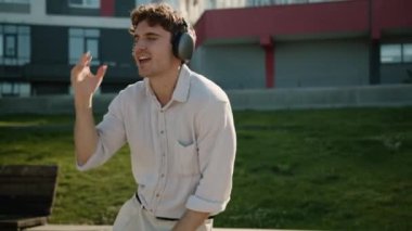 Mutlu Kafkasyalı adam kulaklıkları müzik dinlerken şarkı söylüyor müzik listesi çalıyor erkek şehir dışında dansçı erkek iş adamı aktif kulaklıkların tadını çıkarıyor hafta sonu eğlencesine şehir işlerini kutluyoruz.