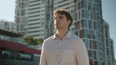 Avrupalı genç bir erkek, iş adamı işçi işçi girişimci turist dışında sokaklarda dolaşıyor. Etrafa bakınıyor. Düşünceli bir şekilde iş binası inşaatı yapıyor.