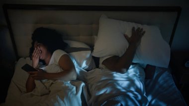 Afrika kökenli Amerikalı çift, yatak odasında sinirli erkek koca, karısını rahatsız etmeye çalışıyor. Kadın kahkaha atıyor, alet bağımlısı, uyuyan cep telefonu bağımlılığını rahatsız ediyor.