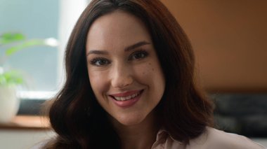 Kadın yüz resmi reklamı. Kendine güveni tam beyaz, Avrupalı bir kadın. İç mekan kliniğinde poz veren kameraman kıza bakıyor.