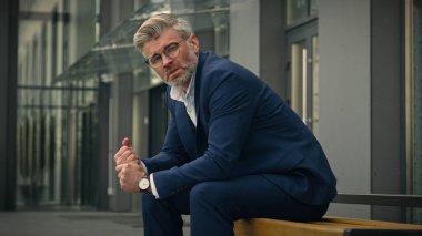 Düşünceli, üzgün, üzgün, düşünceli, orta yaşlı, düşünceli, yaşlı, olgun, iş adamı. Düşünen, düşünceli, sorunlu, sorunlu, kederli, gözlüklü, açık havada düşünmeyi hayal eden işadamı.