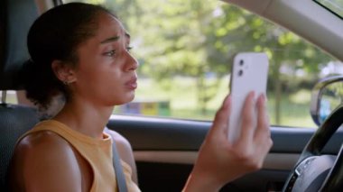 Üzgün, Afrikalı, Amerikalı kadın, arabada oturan, otomobil taşıma sorunu cep telefonu, akıllı telefon, video, iş kadını, içerideki kız sorunlarından endişe ediyor.