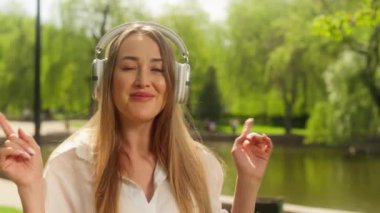Avrupalı mutlu kadın müzik dinliyor hafta sonu kulaklıkları şarkı söylüyor müzik listesi kablosuz dinlenme kız cihaz aleti elektronik teknoloji dansçısı kulaklıklar gülen ses mp3