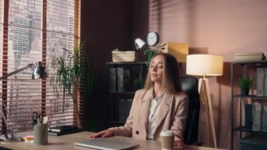 Mutlu pozitif motivasyonlu Kafkasyalı iş kadını kadın iş kadını kadın serbest çalışan yönetici masasında oturuyor kahve içip el parmaklarını uzatarak ofiste bilgisayarın bilgisayarını daktilo etmeye hazır.