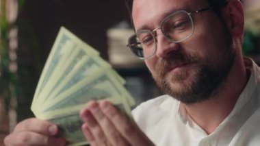 Gülümseyen Kafkasyalı şirket patronu adam mutlu varlıklı girişimci işçi elinde banknotlar sallayan CEO 'lar ofis işindeki hayranlar kazanç, maaşlar, nakit para, finans.