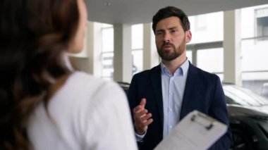 Kadın kadın tüccar müşteriye danışıyor... galeride yeni araba satışı yapan müşteriyle konuşuyor... iş adamına... iş adamına... lüks otomobil satın alan adama... araba kiralama test sürüşü yapan bayiye...