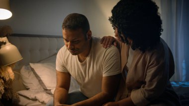 Afro-Amerikalı üzgün adam, gece yatağında oturup üzüntüden kahroluyor. Ereksiyon bozukluğu çeken, sevgi dolu kadın. Rahatlatıcı destek veren empati krizi, iktidarsızlık sorunu, iktidarsızlık sorunu.
