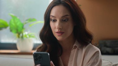 Heyecanlı, mutlu, şaşkın, beyaz kadın kazanan cep telefonuyla kazandı. Başarılı bahisler kazandı. Akıllı telefon çığlıklarıyla zafer kazandı.