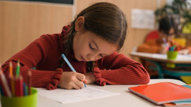 Kafkas zeki, mutlu, küçük kız okulu sınav ödevi notlar yazma dersini öğrenin, çocuk, çocuk, çocuk, ilköğretim öğrenciliği öğrenin, masa başında gülümseyen bir şekilde.