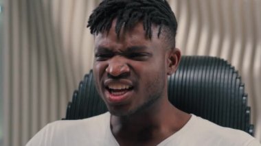 Fütürizm Afro-Amerikalı etnik erkek adam beyaz fütüristik odada siber uzay modern teknoloji çığlık çığlığa bağırıyor kızgın, çılgın, agresif çığlık çığlığa bağırıyor