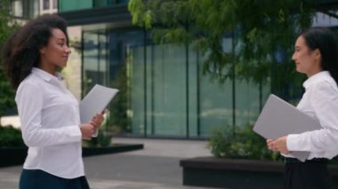 Afrikalı Amerikalı Koreli kadınların tokalaşması iş arkadaşları iş arkadaşlarıyla iş ortakları klasör evrakları evraklar sözleşme anlaşmaları kızlar şehir dışında diyalog anlaşmaları