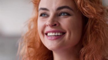 Yüzünüzü kapatın mutlu dişçilik kliniği müşterisi mutlu gülümseme mutlu gülümseme neşeli gülümseme dişli sağlıklı kızıl saçlı beyaz kadın evde kameralı tıp kredisi sigortalarına bakıyor.