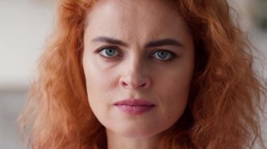 Kapalı kadın yüzü, ciddi derecede sinirli negatif ruh hali, hayal kırıklığına uğramış, hayal kırıklığına uğramış, kızıl saçlı, beyaz saçlı kadın ev kredisi sigortalarına bakıyor.