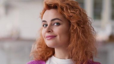 Mutlu gülümseyen portre pozitif kaygısız gülümseme dişli sağlıklı dişler kızıl saçlı beyaz kadın ev sahibi kameraya bakıyor ev sahibi memnun edici ilaç kredisi sigortası