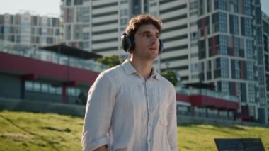 Kameraya bakan Avrupalı beyaz bir adam müzik kulaklıkları dinliyor mp3 erkek iş adamı şehir dışında sound street sound kablosuz öğrenci rahatlama aygıtı