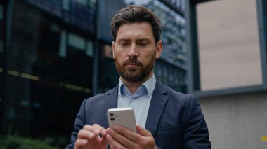 Beyaz adam resmi takım elbiseli iş adamı iş adamı girişimci iş adamı emlakçı şehir merkezindeki cep telefonlu ofis binasının önünde sohbet eden cep telefonu konuşmasına cevap veren emlakçı.