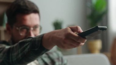Mutlu kahkahalar Kafkas erkek ev sahibi sakin bir hafta sonu eğlencesinin tadını çıkarıyor uzaktan kumandayla televizyon izlerken komik film izliyor.