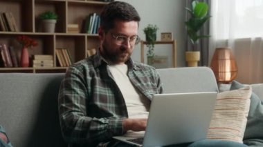 Kafkasyalı erkek, serbest çalışan iş adamı online alışveriş bilgisayarı uzak iş yerlerinde internet sitelerinde gezinen ev yapımı mutlu bir jest öneriliyor.