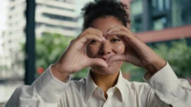 Yüzünüzü kapatın mutlu Afro-Amerikalı kadın işaret işareti gösteriyor. Parmaklarınızı birleştirin. Çerçeve şeklinde gülümseyin.