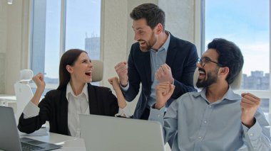 Mutlu yaratıcı ekip ofisteki zaferi kutluyor. Başarılı borsa verileri çevrimiçi iş adamları ve iş kadınları belge dizüstü bilgisayarlarıyla takım çalışması yaparak takım çalışması kazanıyorlar.