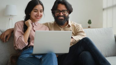 Evli, Arap bir çift. Arkadaşlarını selamlıyor. İnternette video görüntülü konuşma. Ev yapımı Hint etnik kökenli koca, karantinada dostça sohbet eden bir kadınla konuşuyor.