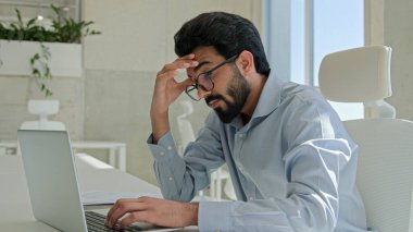 Arap Hindistanlı adam yorgun, yorgun, bilgisayar başında çalışan, hasta iş adamı, kaşıntılı gözleri ovuşturan, ofiste fazla çalışan erkek işveren, gözlük çıkartan, baş ağrısı çeken, kötü bir vizyon hisseden, yorgun.