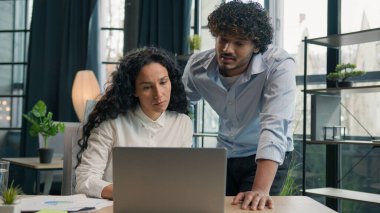 Hintli Arap erkek antrenör akıl hocası lider işadamı İspanyol iş kadınlarına yardımcı oluyor. Stajyer öğretmenler online yazılım açıklıyorlar. Laptop iş dünyası hakkında pazarlama verilerini tartışıyorlar.