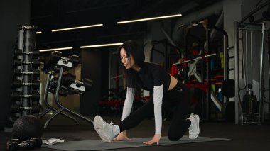Beyaz tenli sporcu spor eğitmeni spor eğitmeni atletik kadın egzersiz, yoga antrenmanı vücut esnetme sportif spor salonu sağlıklı yaşam tarzında fitness minderi üzerinde aktif fit kız eğitimi.