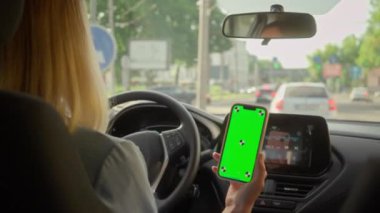 Tanımlanamayan Kafkasyalı iş kadını araba şoförü kadın direksiyon şoförü şehir otomotiv alıcısı kadın cep telefonu yeşil ekranlı GPS navigatör uygulaması kiralık otomobil aracı