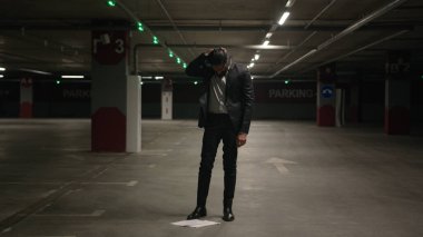 Stresli Hintli adam yeraltı otoparkında gerilimden muzdarip. Stres krizi yüzünden başı ağrıyan erkek işadamı.