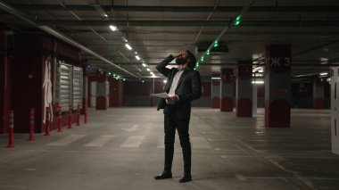 Sinirli, stresli, Arap bir adam, yeraltı otoparkında kötü haberler okuyan, bankacılık kredisi borçları, borç sorunu, işten çıkarma gibi sıkıntılar hisseden bir kağıt parçası okudu.