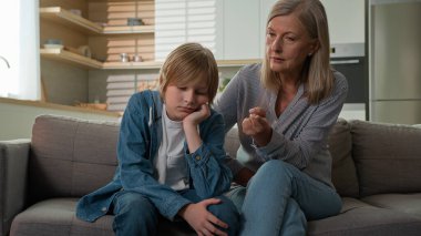 Katı, sinirli, yaşlı, yaşlı, Kafkasyalı, itaatsiz, tembel torunu cezalandıran, kötü davranış disiplini kurallarını açıklayan aile içi anlaşmazlık yüzünden torununu azarlayan yaşlı kadın.