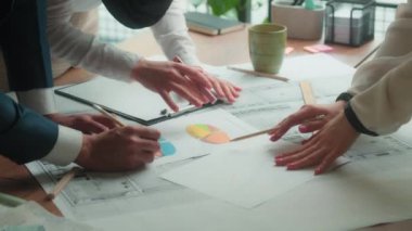 Ofis takım çalışması tartışması mimari planları masa çok ırklı grup mimarlarına inşaat tasarımı projesini çekti. Mühendisler iş adamı kadın iş arkadaşlarının evrak işlerini analiz etti.