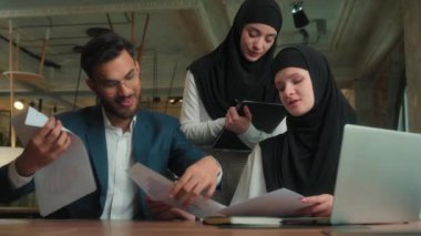 Çok ırklı takım çalışması Hintli iş adamı Müslüman kadın iş kadını görüntülü konuşma internet konferansı iş görüşmesi satış grafikleri ofiste erkek iş arkadaşlarıyla müzakere hakkında konuşuyor