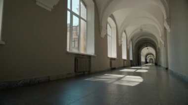 Üniversite koridorunda boş koridor, uzun üniversite koridoru, akademi, kapalı okul, içeride öğrenciler olmadan iç mekan inşaatı, eğitim, güneş ışığı pencereleri, güneş ışığı pencereleri.