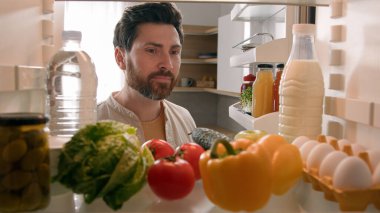 Bakış açısına göre, buzdolabının içinde, beyaz bir erkek, erkek, erkek, ev sahibi, sağlıklı sebzelerle dolu buzdolabı.