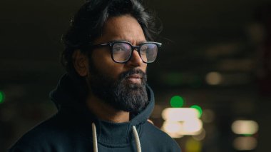 Düşünceli, düşünceli, düşünceli, düşünceli, etnik erkek, şaşkın, karanlık otoparkta düşünen, kafa yoran, kafa yoran, kafa yoran, karar veren, ciddi, kararsız, kararsız, tereddütlü, tek başına çözmeyi bekleyen bir adam.