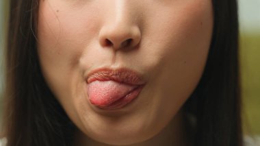 Son derece yakın detaylar, tanınmayan Asyalı bir kadının ağzı, buruşuk dilli bir kızın ağzı dişlek, dişlek, tıbbi sağlık hizmetleri kozmetik güzellik prosedürü, cilt bakımı, dudak dolgusu.