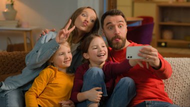 Kafkasyalı mutlu aile annesi, babası küçük kızları cep telefonuna ekşi fotoğraf koyan çocukları komik ebeveynler internet blogu akıllı telefon sosyal medya uygulamasını kaydediyor.