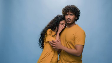 Çok ırklı, korkmuş, korkmuş bir çift Hintli erkeğin arkasına saklanan İspanyol kadını şoke etti. Şaşkınlık. Korkunç korku reaksiyonu.