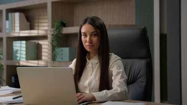 Mutlu gülümseyen Kafkasyalı ofis çalışanı bilgisayar başında sohbet eden müşterilerle iş kadını işveren bayan girişimci yönetici kadın iş kadını kameraya dizüstü bilgisayarla gülümsüyor.