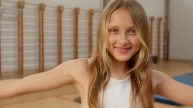 Mutlu, kendine güvenen, kaslarını gösteren beyaz bir kız. Güçlü kollar. Güç şampiyonu, beden eğitimi öğretmeni.