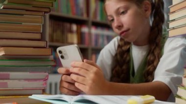 Küçük beyaz kız, sıkılmış okul çocuğu ergen öğrenci, motivasyonsuz öğrenci öğrenci, can sıkıntısı cep telefonu sohbeti, akıllı telefon, sosyal medya, ev içi kütüphane dersleri.