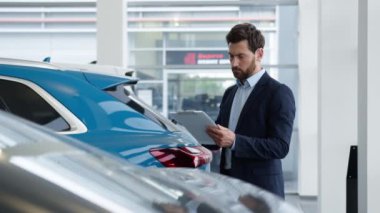 Belge okuyan beyaz bir adam. Satış danışmanı, danışman. Pano araba, otomobil satıcısı, iş adamı.